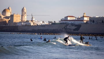 Surfistas cogiendo ola en la playa de Santa María del Mar, Cádiz, tras las medidas de desescalada del Gobierno con altas temperaturas durante el fin de semana.