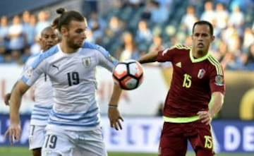 El uruguayo Gastón Silva disputa el balón con el venezolano Alejandro Guerra.