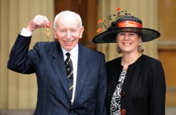 John Surtees posa con su mujer Jane Surtees tras recibir la medalla de la Real Orden del Imperio Británico de manos de la Reina Isabel II en Buckingham Palace en febrero de 2009.