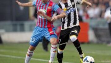 El jugador del Udinese Nico López pelea por el control del balón con el jugador del Catania Mariano Izco, durante el partido de la Serie A italiana disputado en el estadio Friuli de Udine, el 31 de marzo del 2014.