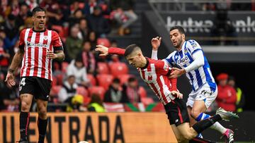Athletic Bilbao's Spanish midfielder Oihan Sancet (C) fights for the ball with Real Sociedad's Spanish midfielder Mikel Merino (R) during the Spanish league football match between Athletic Club Bilbao and Real Sociedad at the San Mames stadium in Bilbao on April 15, 2023. (Photo by ANDER GILLENEA / AFP)