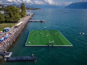 Curiosas fotografías tomadas desde el aire en la que se observa a un grupo de jugadores luchando por el balón en un campo de rugby flotante en el lago Lemán durante el Water Rugby Lausanne, un insólito torneo de tres días organizado por LUC Rugby que reunió a más de 240 jugadores en Lausana, en el oeste de Suiza.