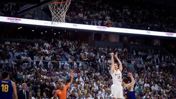 GRAF9251. MADRID, 15/06/2019.- El alero estadounidense del Real Madrid Jaycee Carroll (2d) lanza a canasta junto a Víctor Claver, del FC Barcelona Lassa, durante el primer partido de la final de la Liga ACB que se juega esta noche en el Palacio de los Deportes, en Madrid. EFE/Luca Piergiovanni