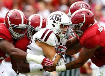 Boone Niederhofer de los de Texas A & M Aggies es abordado por Da'Shawn Mano, Geno Smith, DePriest Trey y Ryan Anderson de la Alabama Crimson Tide en Bryant-Denny