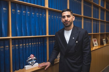 Ilia Topuria posa con los tomos donde se guardan los periódicos históricos en la redacción del Diario AS.