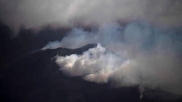 The Cumbre Vieja volcano, pictured from Los Llanos de Aridane, spews ash and smoke on the Canary island of La Palma on December 10, 2021. - The Cumbre Vieja volcano has been erupting since September 19, forcing more than 6,000 people out of their homes as the lava burnt its way across huge swathes of land on the western side of La Palma. (Photo by PIERRE-PHILIPPE MARCOU / AFP)