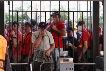Los aficionados del Liverpool se protegen del gas pimienta en los tornos de entrada al estadio. 