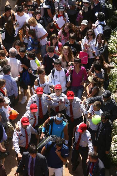 Rafael Nadal se acerca a la pista central rodeado de seguridad y público antes de su partido contra el italiano Potito Starace en 2008. 