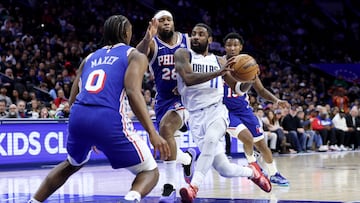 Kyrie Irving, base de Dallas Mavericks, ante Tyrese Maxey y Guerschon Yabusele, de Philadelphia 76ers.