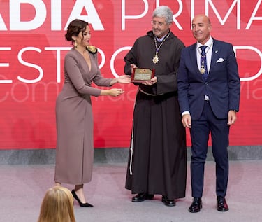 La presidenta de la Comunidad de Madrid, Isabel Díaz Ayuso (i), entrega una Encomienda a Benjamín Echeverría (c), padre superior de la Fraternidad de Jesús de Medinaceli, y a Miguel Ángel Izquierdo, vice hermano mayor de la Archicofradía, en representación de la Basílica de Nuestro Padre Jesús de Medinaceli en Madrid y la Archicofradía Primaria de la Real e Ilustre Esclavitud de Nuestro Padre Nazareno de Medinaceli.
