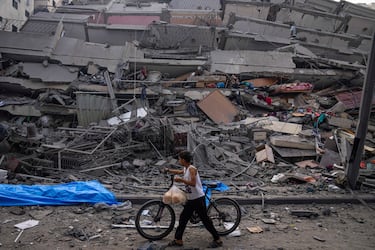 Un ni?o palestino camina con una bicicleta entre los escombros de un edificio despus de que fue alcanzado por un ataque areo israel, en la ciudad de Gaza.
