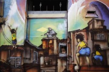 MAYO 2014. Un niño mira a través de la ventana de su casa de Sao Paulo pintada con graffitis con motivos de la Copa del Mundo de Brasil 2014. 

