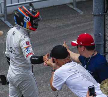 Fernando Alonso saluda a unos aficionados tras tener que abandonar por fallo del motor. 