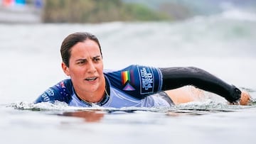 Tyler Wright, bicampeona del mundo de surf, remando con la bandera LGTBIQ+ en la manga de su licra.