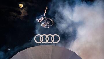 El piloto de MTB Max Fredriksson no hands de noche con la luna al fondo sobre una antena con el logo de Audi en el &uacute;ltimo Audi Nines MTB.