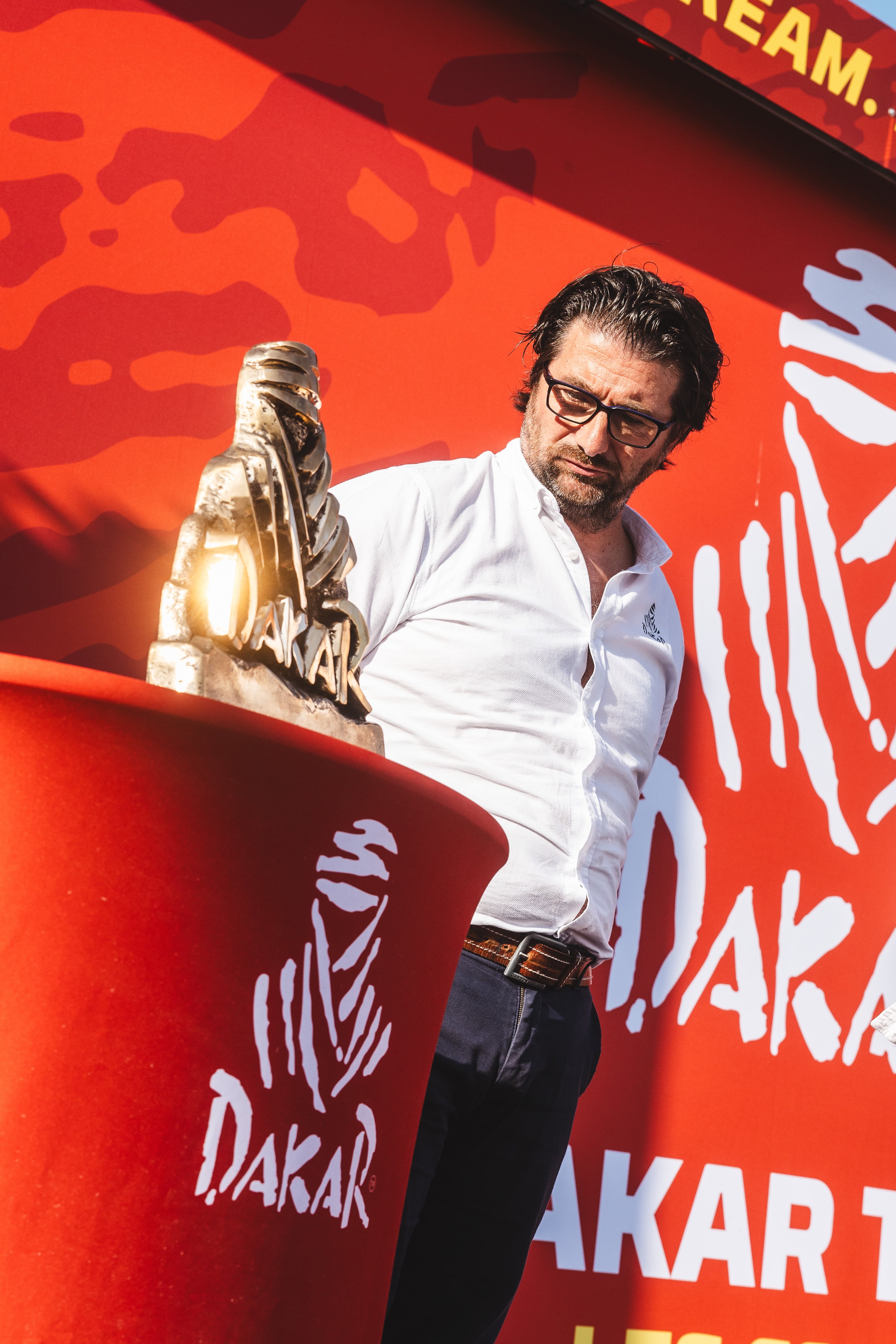 David Castera, director del Dakar, mira el trofeo Touareg.