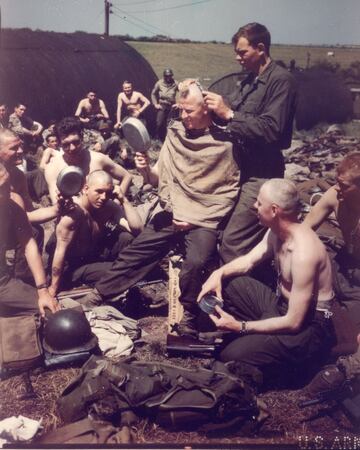 Antes de la invasión del Día D, un barbero militar estadounidense, el cabo Jack Bramhamp, afeita las cabezas de un grupo de soldados en una base no especificada.