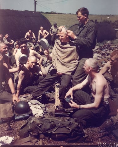 Antes de la invasión del Día D, un barbero militar estadounidense, el cabo Jack Bramhamp, afeita las cabezas de un grupo de soldados en una base no especificada.