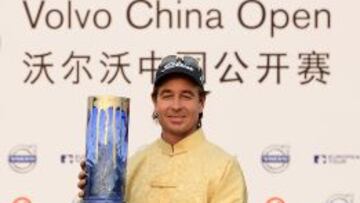 El vencedor del Abierto de China, Brett Rumford, posando con el trofeo en el podio.