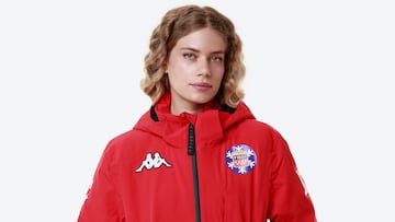 Chaqueta de nieve roja de Kappa para la Federación Madrileña de Deportes de Invierno lucida por una mujer con el pelo rubio.