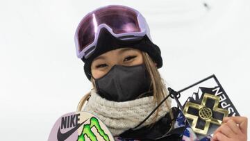 La snowboarder Chloe Kim, con mascarilla negra, m&aacute;scara de nieve y la tabla de snowboard asomando por la parte izquierda, mostrando su medalla de oro en los X Games de Aspen (Colorado, Estados Unidos) 2021. 