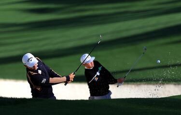 El taiwanés Kevin Yu y el surcoreano Sungjae Im practican a la vez la sacada de bunker en el hoyo 10 de Augusta National durante una ronda de entrenamiento previa al inicio del Masters, el primer major de golf del año, que da comienzo mañana. Jon Rahm, Sergio García, José María Olazábal y José Luis Ballester componen la representación española.