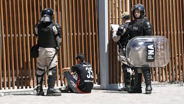 Security forces detain a River Plate's supporter outside the Monumental stadium in Buenos Aires, after the all-Argentine Copa Libertadores second leg final match against Boca Juniors was postponed on November 25, 2018. - The second leg of the Copa Libertadores final has been postponed for the second time in as many days following an attack on the Boca Juniors team bus by River Plate fans, Conmebol said Sunday. (Photo by Juan Mabromata / AFP)