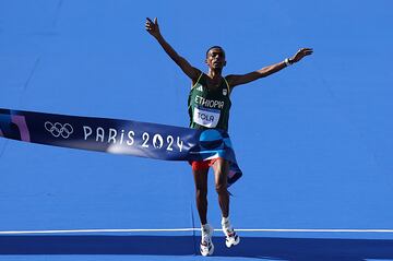 Comentario atribuido a Paul Gilham, director global de deportes en Getty Images 
En esta fotografía, la fotógrafa de Getty Images Hanna  Peters capturó el momento culminante en que un atleta etíope cruza la meta del maratón en los Juegos Olímpicos de París 2024, con los brazos en alto en señal de triunfo. El contraste entre el vibrante azul de la pista y su uniforme verde y rojo resalta la emoción y la importancia de su victoria. Con esta imagen, Hanna reflejes  no solo la victoria individual, sino también la esencia de la resistencia humana y el espíritu olímpico que trasciende fronteras.
