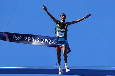 Comentario atribuido a Paul Gilham, director global de deportes en Getty Images 
En esta fotografía, la fotógrafa de Getty Images Hanna  Peters capturó el momento culminante en que un atleta etíope cruza la meta del maratón en los Juegos Olímpicos de París 2024, con los brazos en alto en señal de triunfo. El contraste entre el vibrante azul de la pista y su uniforme verde y rojo resalta la emoción y la importancia de su victoria. Con esta imagen, Hanna reflejes  no solo la victoria individual, sino también la esencia de la resistencia humana y el espíritu olímpico que trasciende fronteras.

