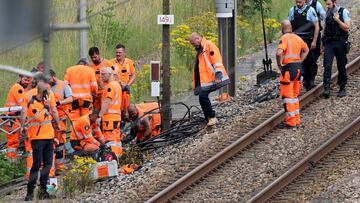 SNCF employees and French gendarmes inspect the scene of a suspected attack on the high speed railway network at Croiselles, northern France on July 26, 2024. French security forces are hunting people behind arson attacks that hobbled the country's high-speed rail network hours before the Olympic Games opening ceremony, Prime Minister Gabriel Attal said. (Photo by Denis CHARLET / AFP)