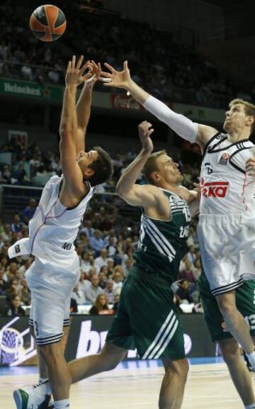 Los jugadores del Real Madrid Felipe Reyes y Nocioni luchan por un rebote con Javtokas.