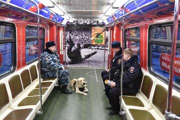 Agentes de policía con un perro montan en un tren de metro temático de la Copa Mundial FIFA 2018 después de la presentación del cartel oficial de los torneos de fútbol en Moscú el 28 de noviembre de 2017.