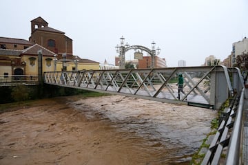 Un hombre cruza un puente sobre el río Guadalmedina cerca del centro histórico de la ciudad de Málaga.