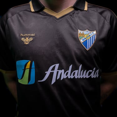 La camiseta está inspirada en las temporadas 2001/2002 y 2002/2003 del Málaga CF, una etapa que simboliza el renacimiento del club y su consolidación en Primera División, culminada con la conquista de la Copa Intertoto en agosto de 2002, su primer título europeo. Aquel periodo quedó marcado por una generación que devolvió la ilusión a la afición y por figuras como Sebastián Fernández Reyes, “Basti”, protagonista de los ascensos desde categorías inferiores hasta la élite y símbolo del malaguismo. El diseño recupera esa memoria reciente a través del concepto de legado y transmisión generacional, representado por la presencia de Basti y su hijo, reinterpretando aquella época con una mirada actual para reforzar el vínculo entre identidad, historia y futuro.