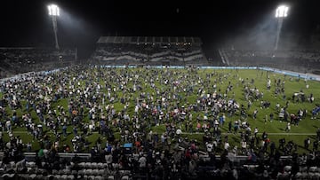 Fans of Gimnasia y Esgrima La Plata affected by tear gas invade the field after the match between Gimnasia y Esgrima La Plata and Boca Juniors in the Liga Profesional 2022 was suspended due clashes between supporters and the police outside the stadium, at Juan Carmelo Zerillo Stadium, in La Plata, Argentina October 6, 2022. REUTERS/Jose Brusco NO RESALES. NO ARCHIVES.