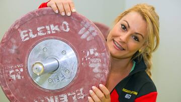 Lydia Valentin posa con un disco de halterofilia.