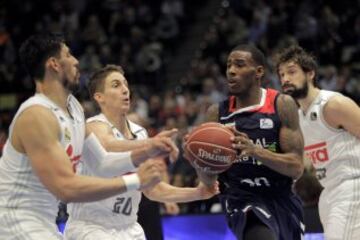 El base estadounidense del Laboral Kutxa Darius Adams entra a canasta ante el mexicano Gustavo Ayón y el norteamericano Jaycee Carroll, del Real Madrid, durante el partido de la segunda semifinal de la Copa del Rey 