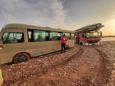 Un miembro de la Media Luna Roja Libia en Ajdabiya junto a vehículos atrapados en el barro en un área afectada por las inundaciones.