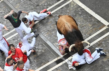 Participantes corren delante de los toros durante el primer encierro de los Sanfermines en Pamplona.