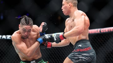 Apr 26, 2025; Kansas City, Missouri, UNITED STATES; Timmy Cuamba (red gloves) fights Roberto Romero (blue gloves) during UFC Fight Night at T-Mobile Center. Mandatory Credit: William Purnell-Imagn Images