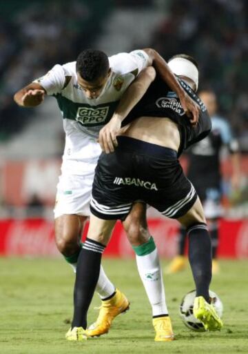 El delantero brasileño del Elche Jonathas de Jesús lucha el balón con Andreu Fontás, del Celta de Vigo, durante el partido de la sexta jornada de Liga de Primera División que se disputa esta noche en el Estadio Martínez Valero, en Elche. 