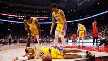 TORONTO, ON - DECEMBER 07: Lonnie Walker IV #4 and Max Christie #10 look down at Juan Toscano-Anderson #95 of the Los Angeles Lakers after he grabs a loose ball against the Toronto Raptors during the first half of their NBA game at Scotiabank Arena on December 7, 2022 in Toronto, Canada. NOTE TO USER: User expressly acknowledges and agrees that, by downloading and or using this photograph, User is consenting to the terms and conditions of the Getty Images License Agreement.   Cole Burston/Getty Images/AFP (Photo by Cole Burston / GETTY IMAGES NORTH AMERICA / Getty Images via AFP)