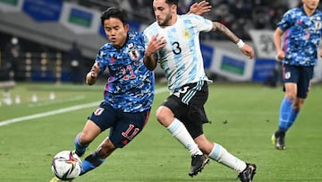 Japan's midfielder Takefusa Kubo (L) and Argentina defender Milton Valenzuela (C) fight for the ball during their Under-24 international friendly football match at Ajinomoto Stadium in Tokyo on March 26, 2021. (Photo by Kazuhiro NOGI / AFP)