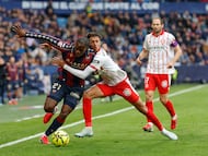 El defensa brasileño del Girona Vitor Reis (c) pelea un balón con el delantero camerunés del Levante Karl Etta Eyong.