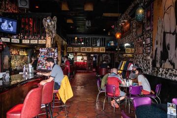 People sit at the bar of a restaurant in Austin, Texas, June 26, 2020. - Texas Governor Greg Abbott ordered bars to be closed by noon on June 26 and for restaurants to be reduced to 50% occupancy. Coronavirus cases in Texas have spiked in recent weeks aft