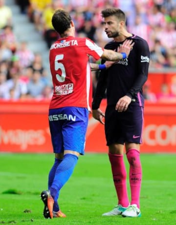 Sporting Gijon's Venezuelan defender Fernando Amorebieta (L) pushes Barcelona's defender Gerard Pique during the Spanish league football match Real Sporting de Gijon vs FC Barcelona at El Molinon stadium in Gijon on September 24, 2016. / AFP PHOTO / ANDER