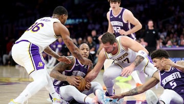 Luka Doncic y Marcus Smart tratan de rboar la bola a DeMar DeRozan.