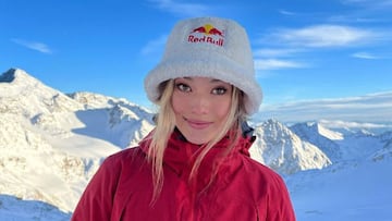 Retrato de la freeskier china Eileen Gu, con chaqueta roja y gorro Red Bull, con montañas nevadas al fondo, en noviembre del 2022.