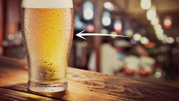 Glass of light beer on the glass bar counter.