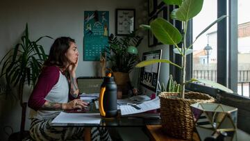 Una mujer realiza teletrabajo en su casa.
